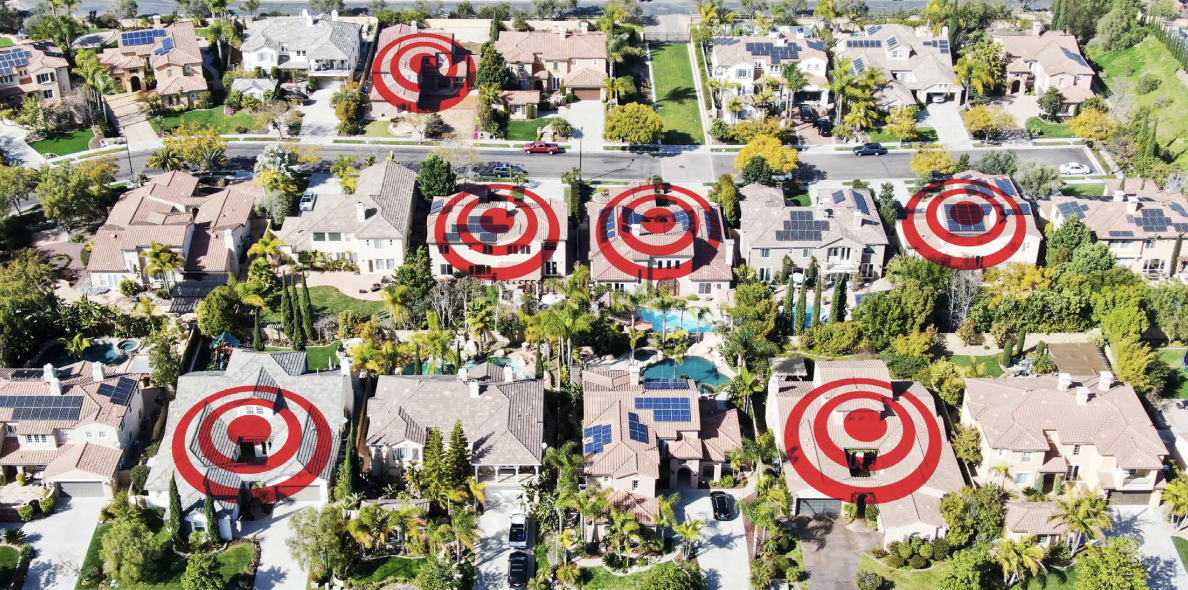 An aerial photograph of a neighbourhood with red targets superimposed over the homes. 