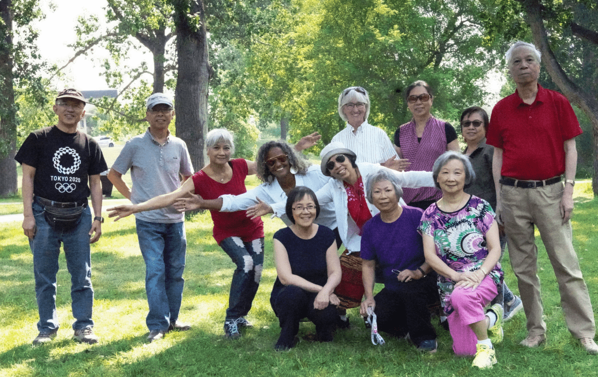  A group of senior members of MPC Foundation pose for a photo together in a park. Un groupe de personnes âgées membres de la MPC Foundation posent ensemble dans un parc