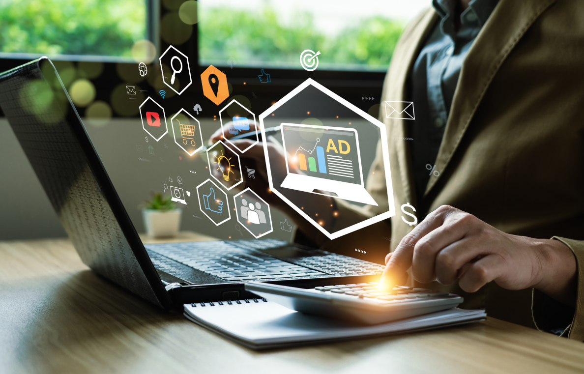 A man works on a laptop, with various digital marketing symbols and icons appearing around the screen.